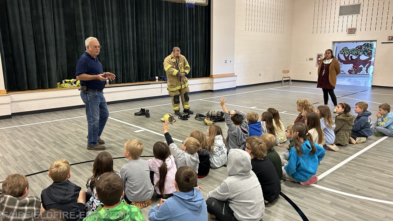 Fairfield Fire Chief William Jacobs and Captain Chad Fogle discussing fire safety and demonstrating the use of fire fighter equipment.