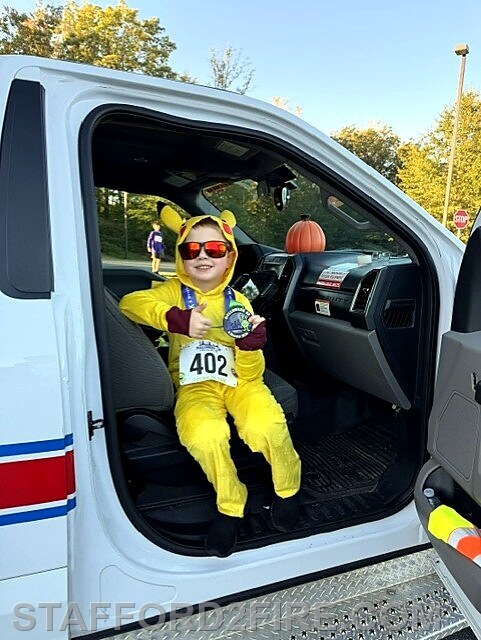A young participant gets an up-close look at a Stafford emergency vehicle during the Halloween 5K and Monster Mile.